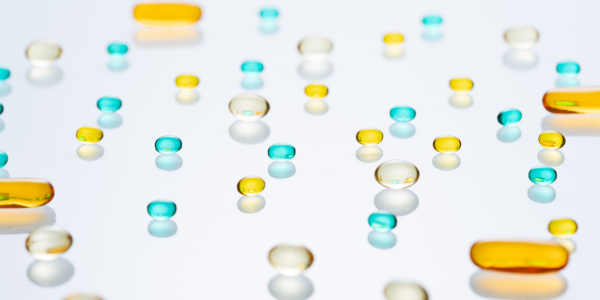 yellow, clear, and blue gel filled pills on a transparent background