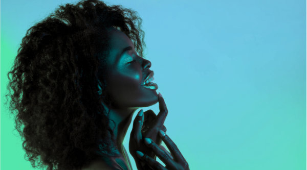 A silhouette of a woman with curly hair smiling