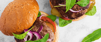 img title A burger in a bun with salad and sesame seeds