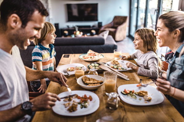 Una familia cenando juntos alrededor de la mesa del comedor.