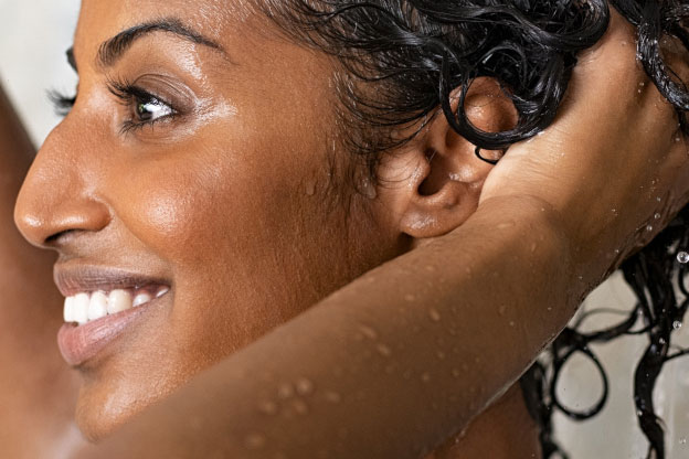 A smiling woman washing her hair