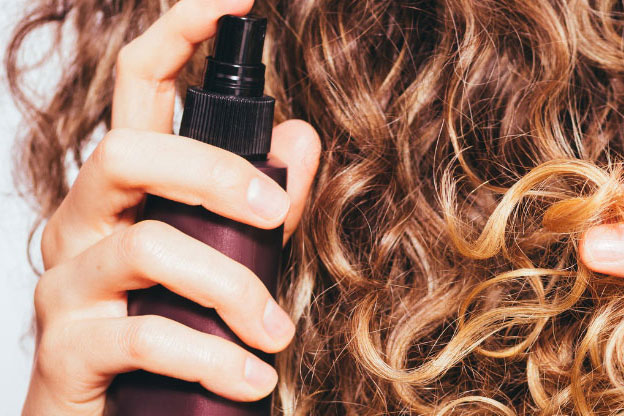 A woman applying hair product