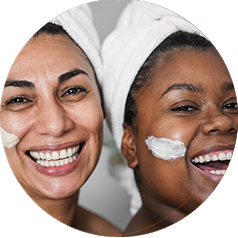 Two women with towels on their hair and cream on their faces
